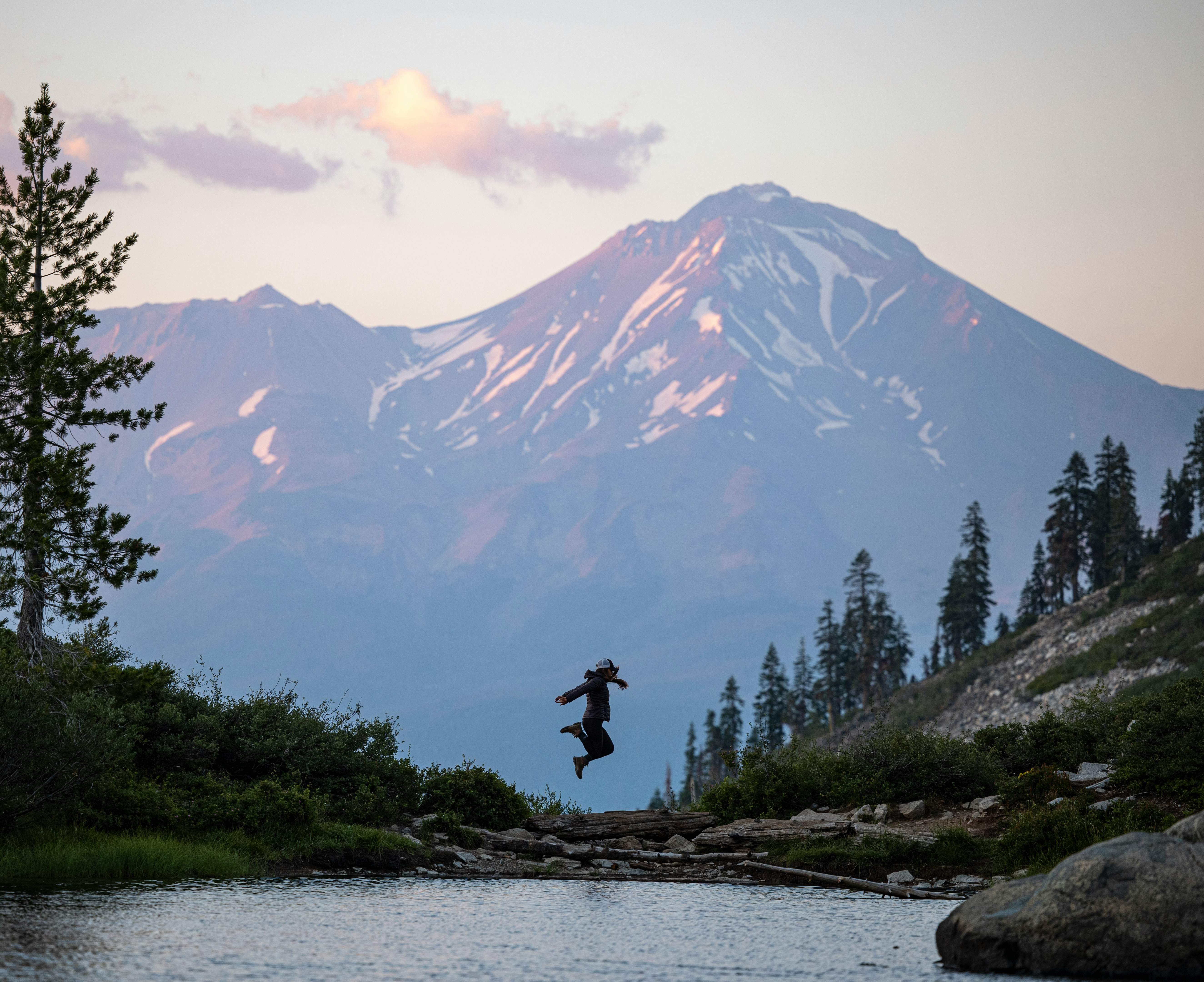 person standing on rock near lake during daytime